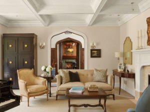 Cozy living room with settee, chair, piano, and fireplace.